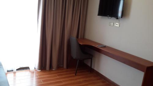 a room with a desk and a television on a wall at Yofel Hotel in Addis Ababa