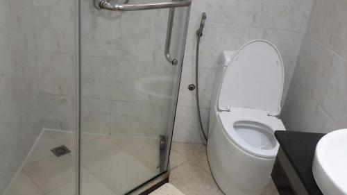 a bathroom with a shower and a toilet and a sink at Yofel Hotel in Addis Ababa
