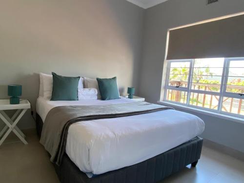 a bedroom with a large bed with a window at 4 La Toinette in Ballito