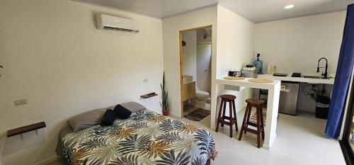 a living room with a couch and a kitchen at Casita Ola N en Caribe Sur in Talamanca