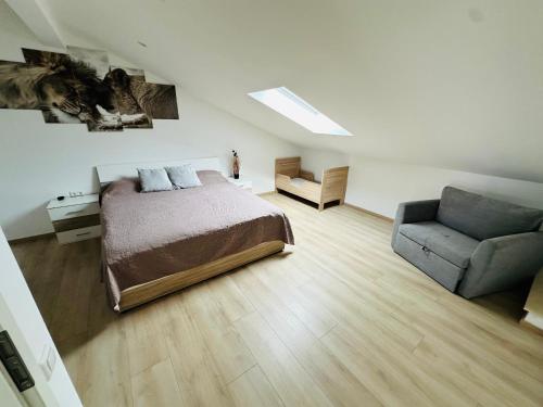 a bedroom with a bed and a couch and a chair at Große Ferienwohnung Gästehaus NEUBAU Merzig 120m2 in Merzig