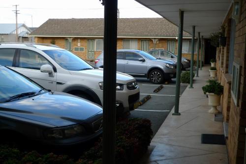 eine Gruppe von Autos, die auf einem Parkplatz geparkt sind in der Unterkunft Parkhaven Motel in Goulburn