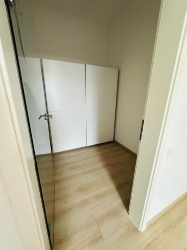 an empty room with a glass door and wooden floor at Große Ferienwohnung Gästehaus NEUBAU Merzig 120m2 in Merzig