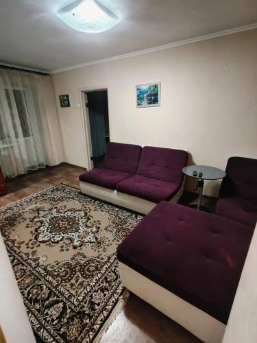 a living room with a purple couch and a rug at Затишна 2-кімнатна квартира для спокійного сімейного відпочинку in Mykolaiv