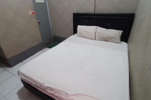 a bedroom with a bed with white sheets and pillows at Hotel O Near Tugu Yogyakarta 2 formerly Monjali Inn in Jetis