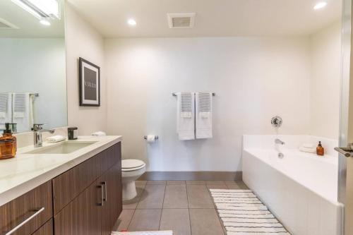 a bathroom with a tub and a toilet and a sink at Trendy 2BD 2BTH Apt steps from Downtown Santa Monica! in Los Angeles