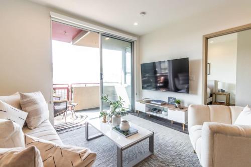 a living room with a couch and a tv at Trendy 2BD 2BTH Apt steps from Downtown Santa Monica! in Los Angeles