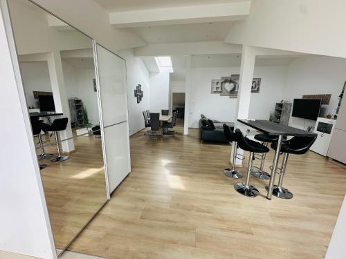 a room with a mirror and a table and chairs at Große Ferienwohnung Gästehaus NEUBAU Merzig 120m2 in Merzig