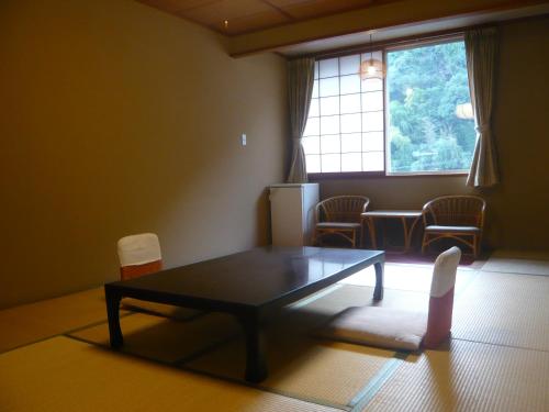 a living room with a table and chairs and a window at Konya in Matsue