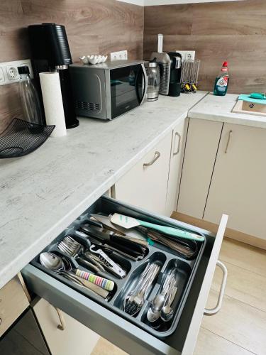 a kitchen with a drawer full of utensils at Große Ferienwohnung Gästehaus NEUBAU Merzig 120m2 in Merzig