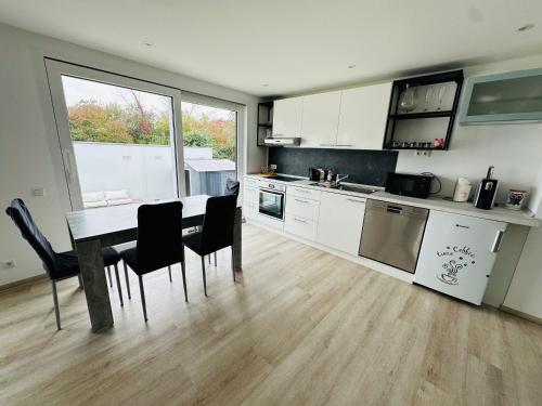 a kitchen with a table and some chairs in a room at FerienWohnung Gästehaus Merzig-Besseringen NEUBAU in Merzig