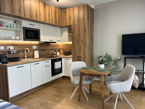 a kitchen with white cabinets and a table and chairs at Apartmány Klement in Znojmo
