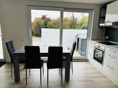 a dining room with a table and chairs in a kitchen at FerienWohnung Gästehaus Merzig-Besseringen NEUBAU in Merzig