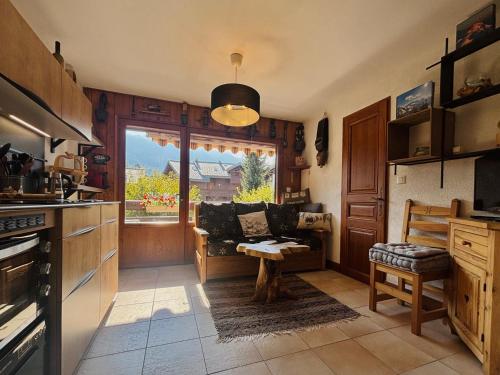 a kitchen with a couch and a table in it at Appartement T3 rénové, lumineux, balcon et parking au centre du village de Samoëns - FR-1-624-73 in Samoëns