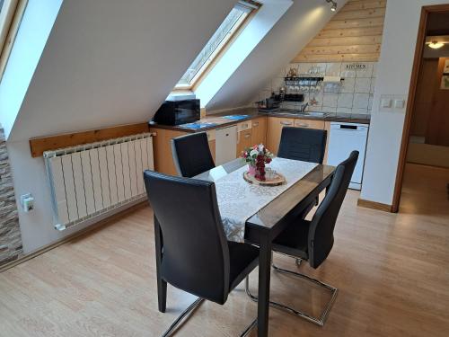 a kitchen with a table and chairs in a room at Apartment Erika in Fužine