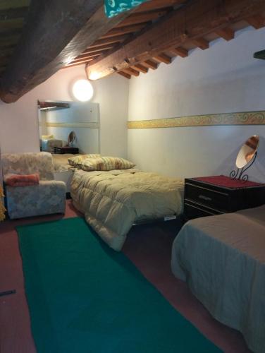 a bedroom with three beds and a chair and a mirror at affittacamere b&b l'aurora Montelparo in Montelparo