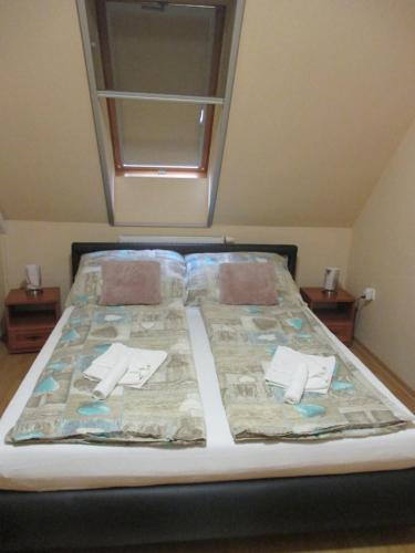 un lit avec deux oreillers dessus dans une chambre dans l'établissement Elizabet Apartman, à Szarvas