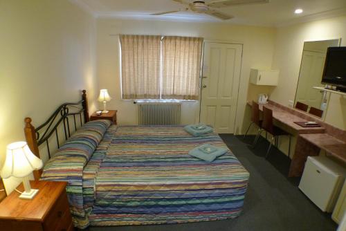 ゴールバーンにあるParkhaven Motelのベッドとデスクが備わるホテルルームです。