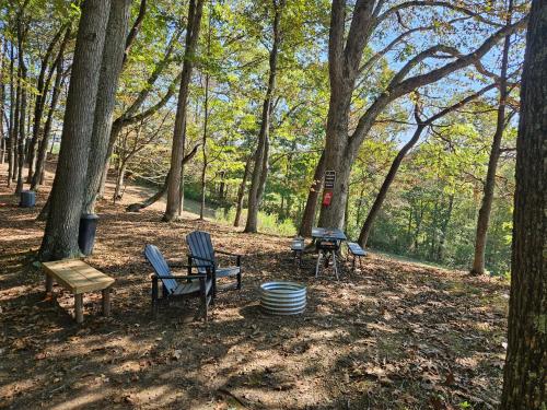 a picnic table and chairs in the woods at The Hocking Hills Store Campsite #3 in Logan