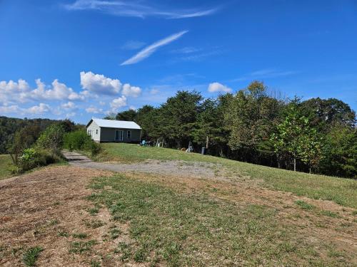 a dirt road leading to a house on a hill at The Hocking Hills Store Campsite #3 in Logan