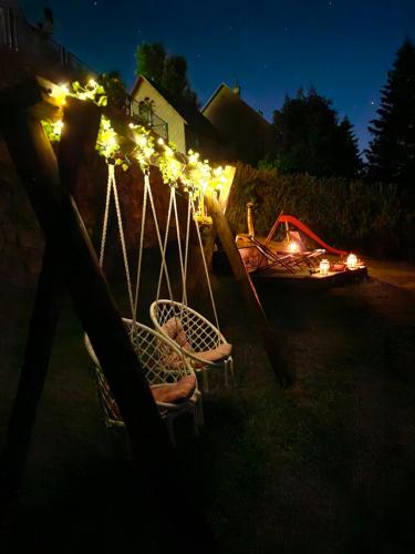 a couple of chairs with lights on a fence at night at Apartment Erika in Fužine