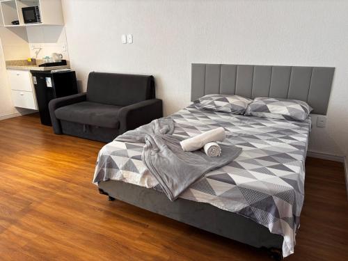 a bedroom with a bed with a chair and a chair at 100 m da Praia do Forte com AR e Wi Fi. in Škorak