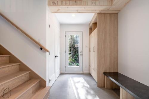 a hallway with white walls and wooden stairs at Mini-chalet #1 Chute-à-Bull St-Côme in Saint Come