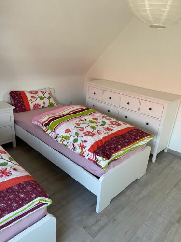 a bedroom with two beds and a dresser at Sweet Home Appartements 2 in Bottrop