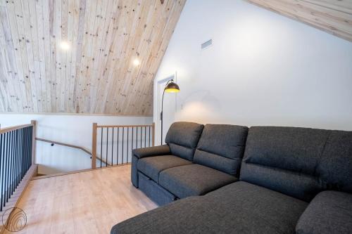 a living room with a couch and a staircase at Mini-chalet #1 Chute-à-Bull St-Côme in Saint Come