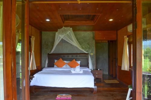 een slaapkamer met een groot bed in een huis bij Romantic Time Mountain Resort in Pai