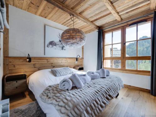a bedroom with a large bed with towels on it at Arc 1950: Apt 10 pers, 4 ch, ski pieds, wellness, wifi - FR-1-686-44 in Arc 1950