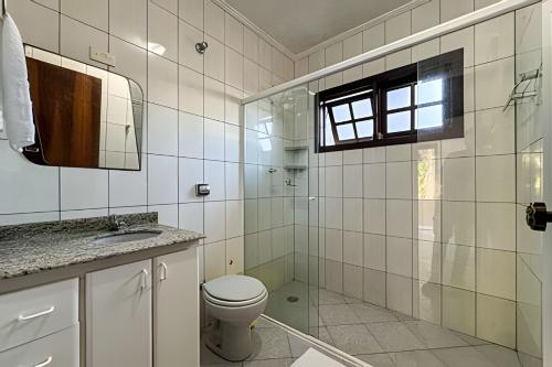 a bathroom with a toilet and a glass shower at Fantastica casa proxima do mar! in Praia Guaratuba