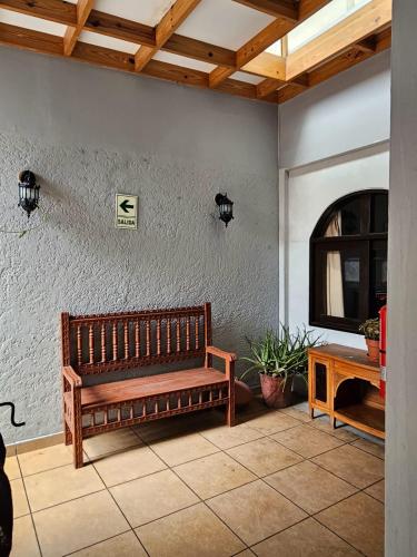 a wooden bench sitting in the corner of a room at Haku Hostel in Lima
