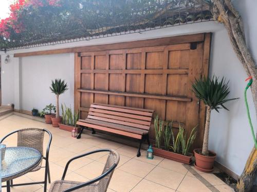 a bench sitting in front of a wall with plants at Haku Hostel in Lima