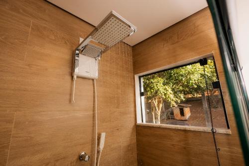 a shower with a fan on a wall next to a window at @Stay22 - Sítio Ypê Amarelo /Alto padrão - Luxuoso in São Lourenço
