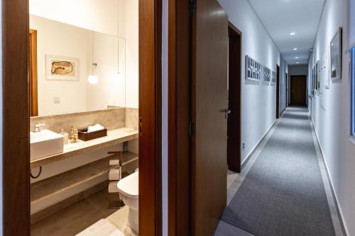 Un baño con lavabo e inodoro y un pasillo. en Paraíso em Boituva - chácara nova, moderna, 2100 m, em condomínio -10 PESSOAS, en Boituva