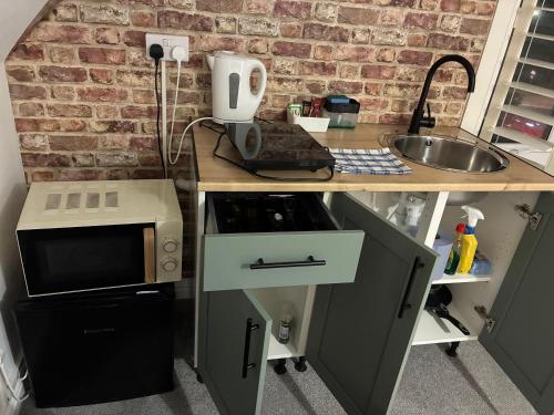 a kitchen with a counter with a microwave and a sink at By-the-Beach, Sea view 2 bedroom Loft Studio Apartment & Free Parking in Portsmouth