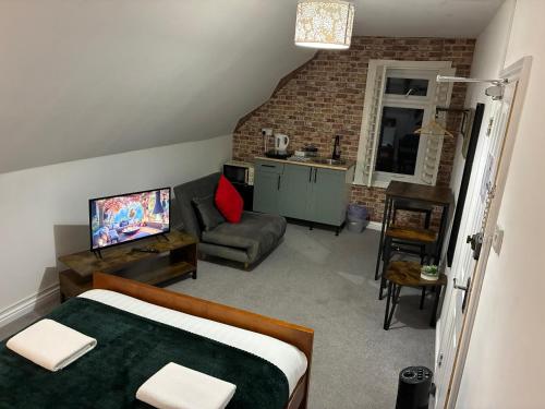 a bedroom with a bed and a couch and a kitchen at By-the-Beach, Sea view 2 bedroom Loft Studio Apartment & Free Parking in Portsmouth