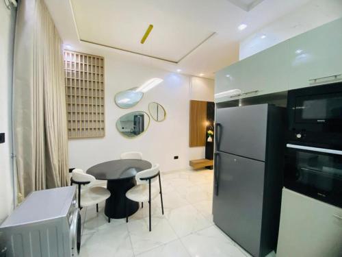 a kitchen with a table and a refrigerator at Cozy Corner Apartments in Lekki