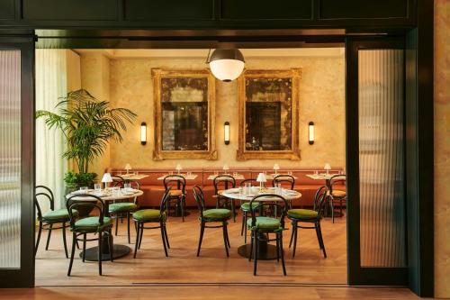 a restaurant with tables and chairs in a room at The Hollywood Grande, Autograph Collection in Los Angeles