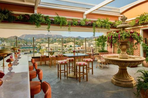 a restaurant with tables and chairs and a view at The Hollywood Grande, Autograph Collection in Los Angeles