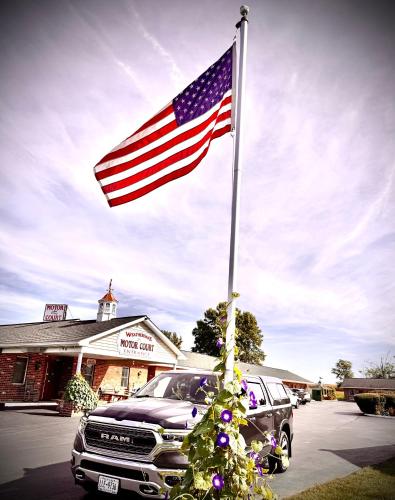 an american flag on a pole in front of a truck at Weathervane Motor Court in Ronks