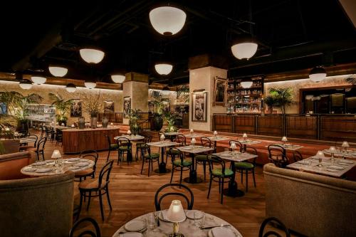 a restaurant with tables and chairs and a bar at The Hollywood Grande, Autograph Collection in Los Angeles