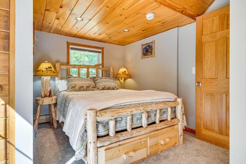 Un dormitorio con una cama de madera y un techo de madera. en On Baxter Lake Wooded Retreat Near Trails, en Rochester