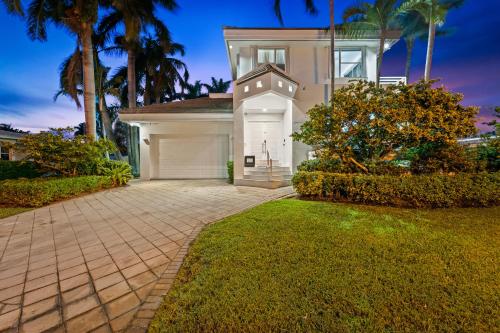 a house with a garage and palm trees at Villa Harrison . in Hollywood Beach