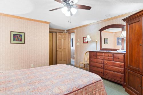 a bedroom with a bed and a dresser and a ceiling fan at ML246 Spacious Condo Mtn & Lake views fireplace in Snowshoe