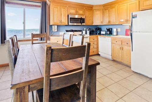 a kitchen with a wooden table and a refrigerator at ML246 Spacious Condo Mtn & Lake views fireplace in Snowshoe