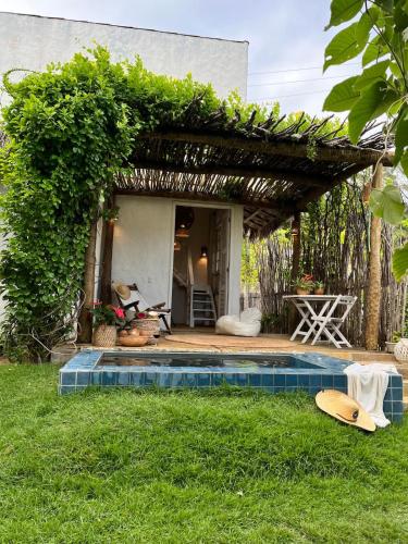 a house with a swimming pool in the grass at KOA Loft - Praia de Moitas in Amontada