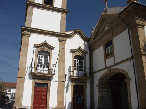 a building with a red door and two windows at VISIt CASTELO BRANCO in Castelo Branco