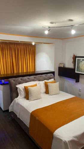 a bedroom with a large bed with orange and white pillows at Apartament Horatio in Galaţi